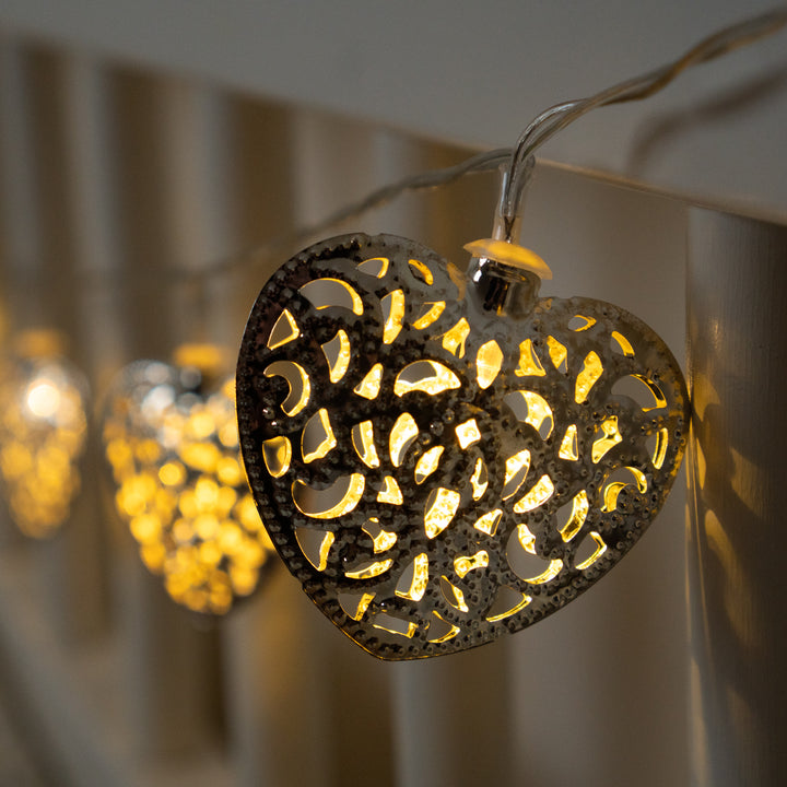 10 LED Silver Filigree Heart Fairy Lights hanging from a railing